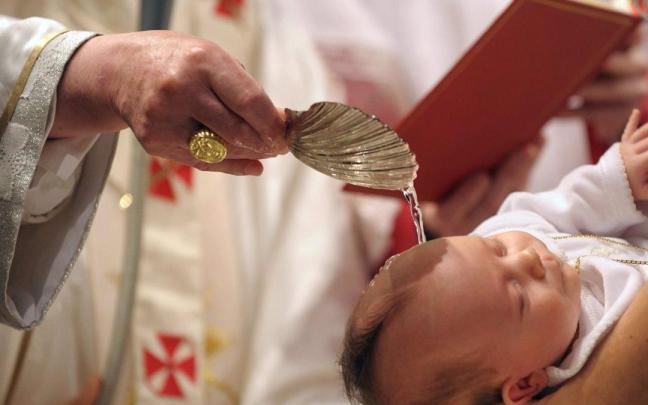 Un sacerdote bautiza a un niño