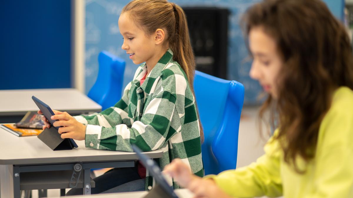 Dos alumnas utilizan una tablet en el aula.