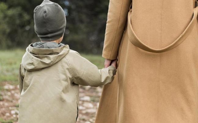 Una madre y su hijo caminan de la mano. Una madre y su hijo caminan de la mano.