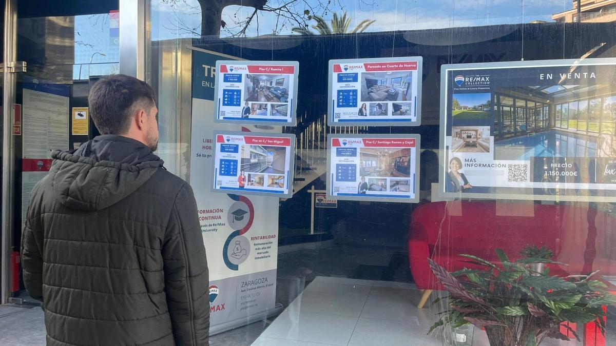 Un hombre mira pisos en venta en una inmobiliaria