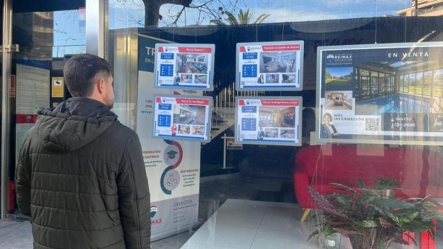 Un hombre mira pisos en venta en una inmobiliaria