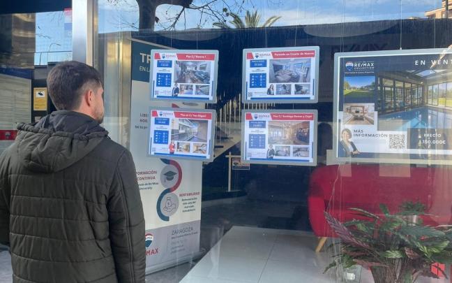 Un hombre mira pisos en venta en una inmobiliaria