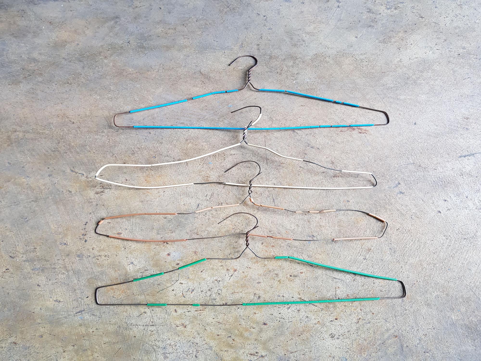 Perchas de alambre deformadas y en muy mal estado.