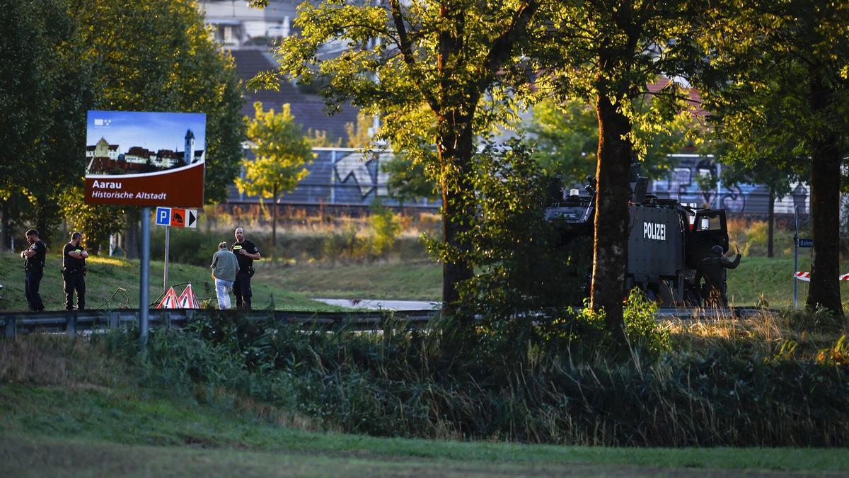 Agentes de policía armados bloquean una calle cerca del hipódromo de Schachen tras un tiroteo ocurrido durante una fiesta rave en dicho hipódromo, cerca de Aarau, Suiza.