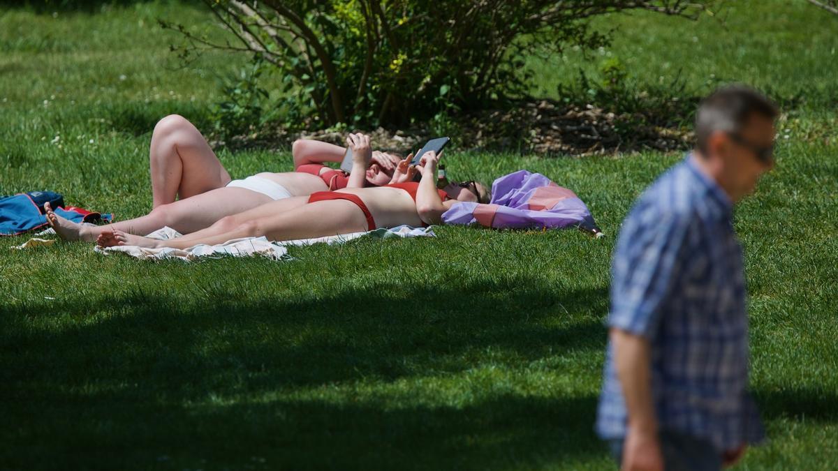 Dos mujeres toman el sol en un parque.