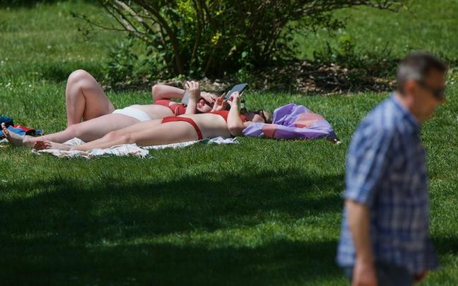 Dos mujeres toman el sol en un parque.