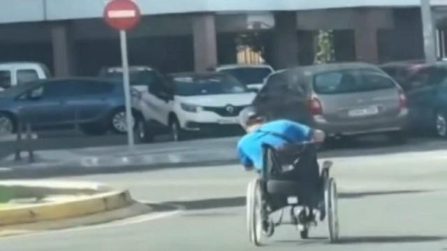 El hombre, inclinándose para tomar mejor la rotonda con la silla de ruedas.