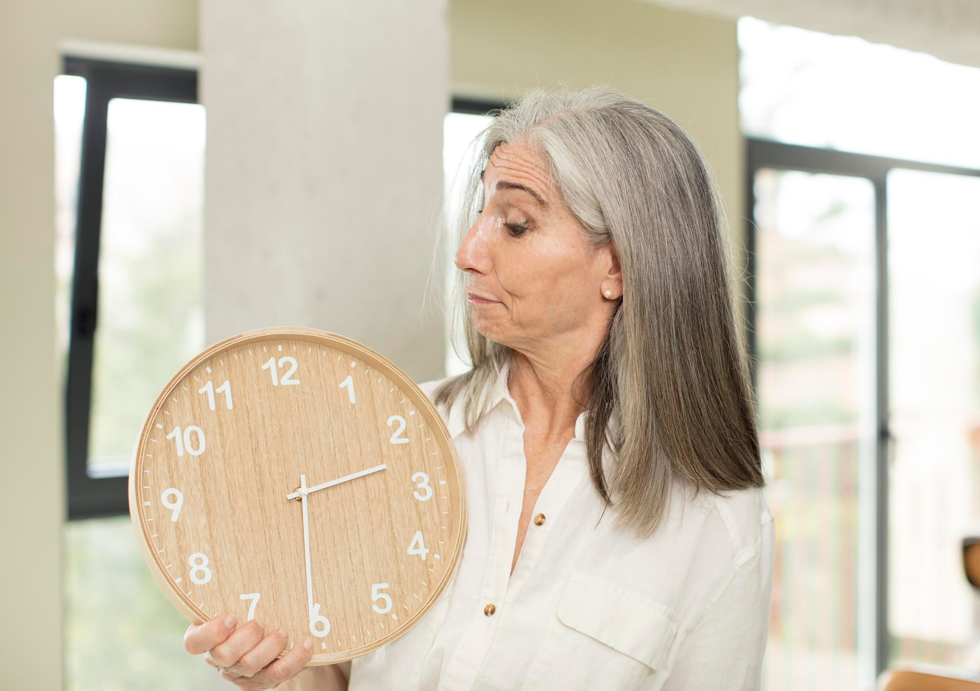 Una mujer mira de reojo el paso del tiempo en un reloj.