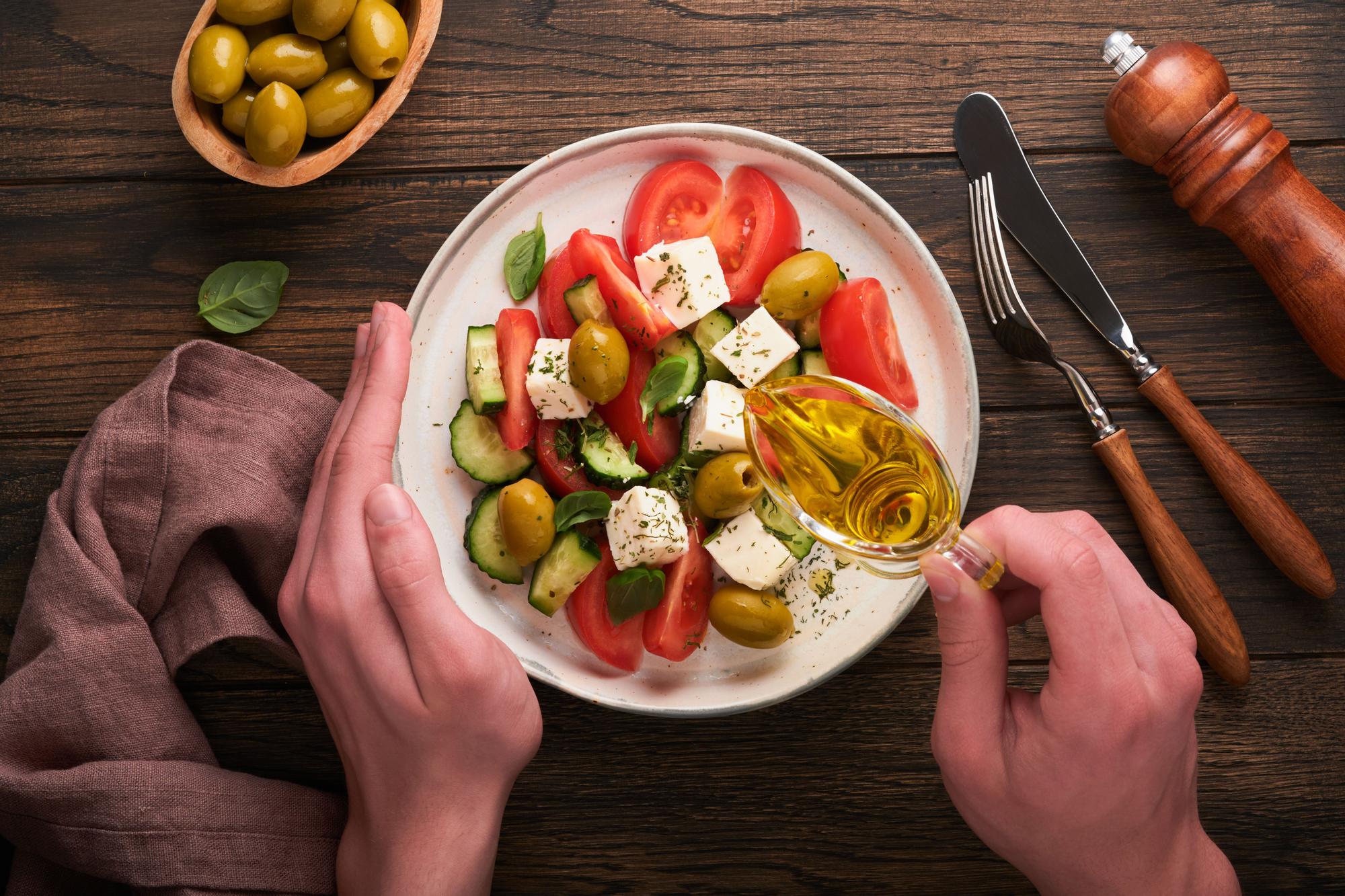Ensalada de tomate, queso y aceitunas con aceite de oliva virgen extra.
