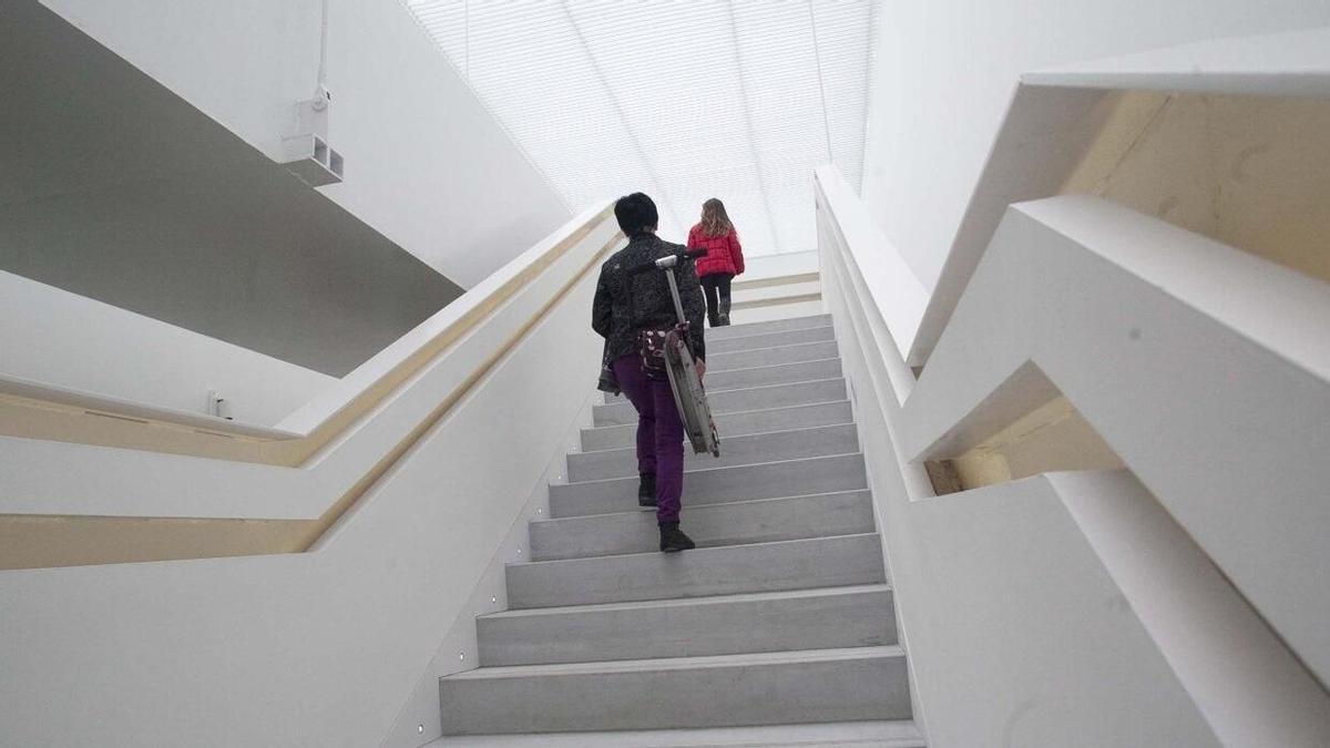 Dos personas suben andando por unas escaleras.