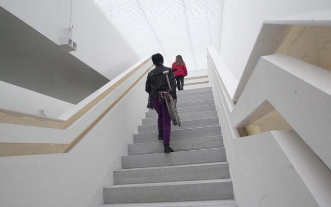 Dos personas suben andando por unas escaleras. Dos personas suben andando por unas escaleras.