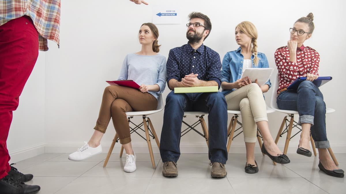 Varias personas esperan para realizar una entrevista de trabajo.