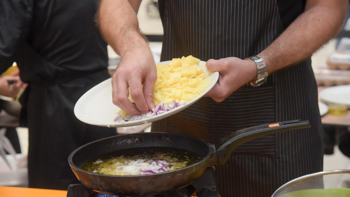 Cocinero prepara una tortilla de patatas con cebolla.