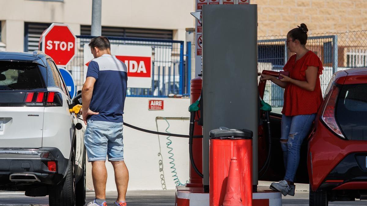 Dos personas echan gasolina a su vehículo en una estación de servicio con unos carburantes que llevan ocho semanas consecutivas de subida.