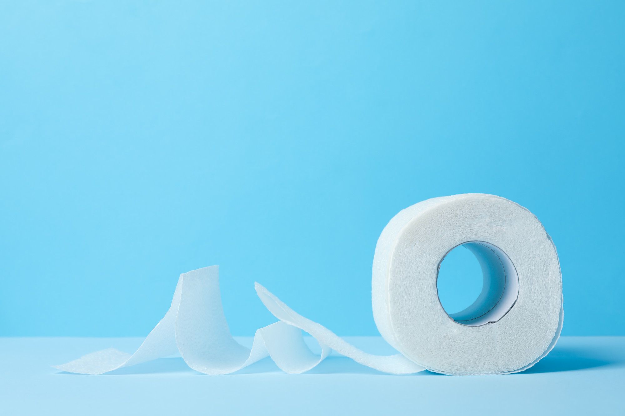 Un rollo de papel higiénico con la hoja suelta por debajo.
