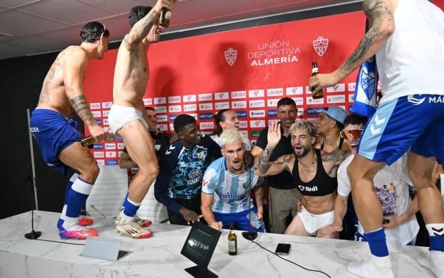 Los jugadores del Málaga celebran el ascenso en la sala de prensa.