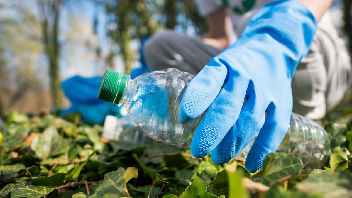 Botellas de plástico y basura acumulada en la naturaleza.