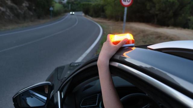 Una persona coloca una luz de emergencia en el techo de un vehículo.