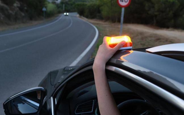 Una persona coloca una luz de emergencia en el techo de un vehículo.