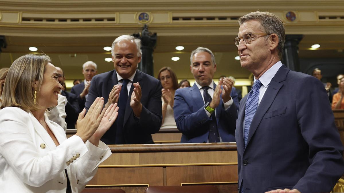 Cuca Gamarra (i) y el resto de diputados del PP aplauden a su líder Alberto Núñez Feijóo (d) a su llegada al Congreso.