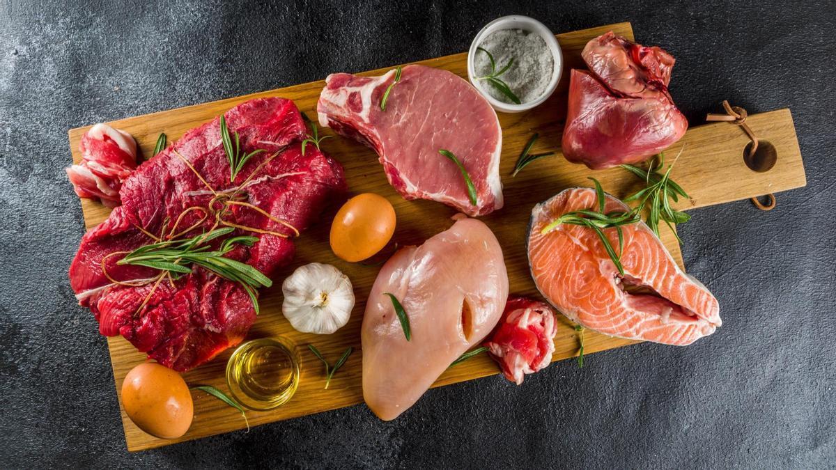 Carnes y pescados crudos comparten espacio en una tabla de cortar.