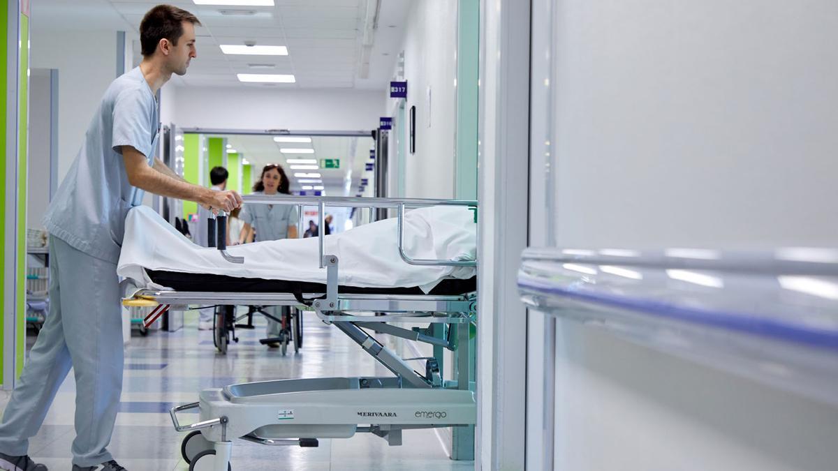 Un sanitario ingresa una camilla en una habitación de un hospital de Osakidetza.