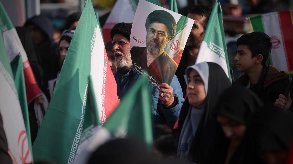 Simpatizantes del régimen iraní portan banderas y retratos de su nuevo líder supremo.