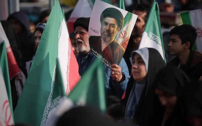 Simpatizantes del régimen iraní portan banderas y retratos de su nuevo líder supremo.