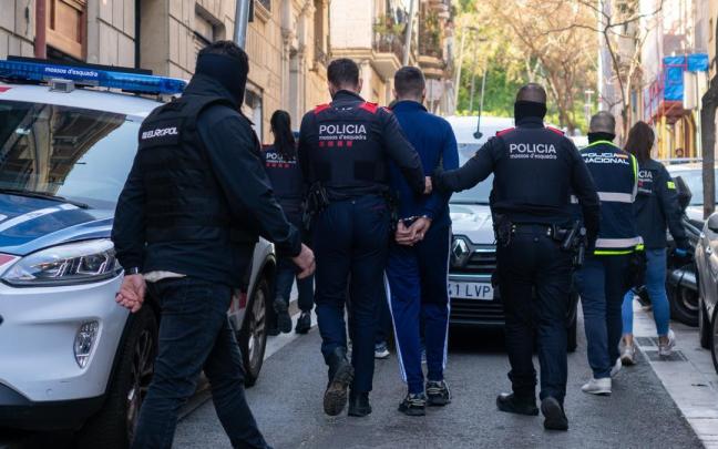 Agentes de los Mossos d'Esquadra se llevan a un detenido durante un operativo policial.