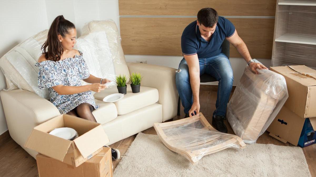 Pareja monta los muebles del salón.