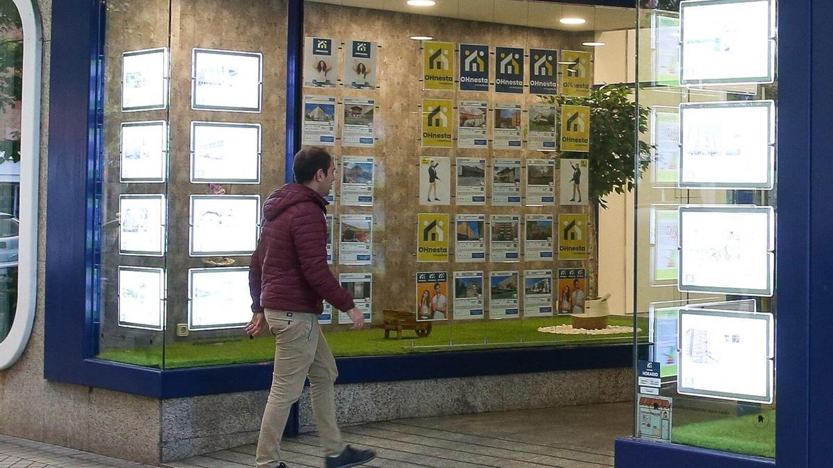 Un hombre accede al interior de una inmobiliaria.