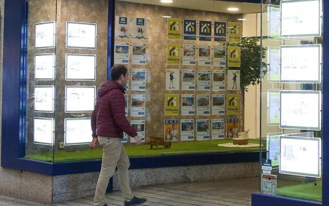 Un hombre accede al interior de una inmobiliaria.