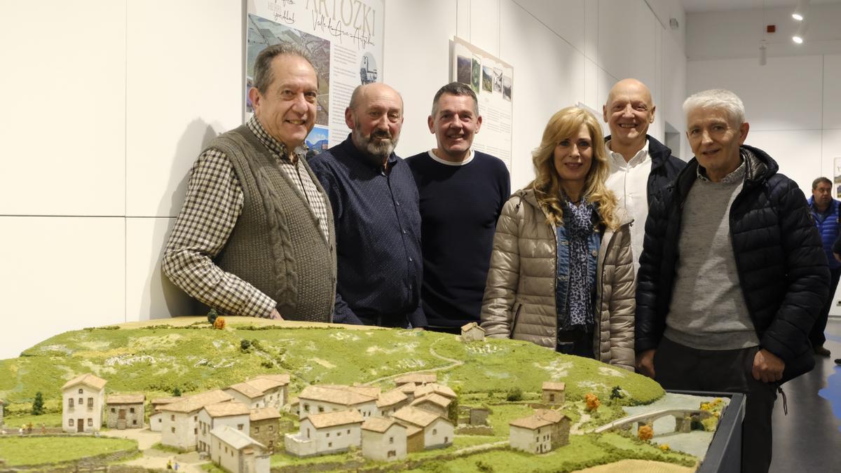 De i a d. Víctor Manuel Eguía, Juan Jesús Leache, Alfredo León y Toño Villanueva (autores) posan en la maqueta de Artozqui con dos vecinos.