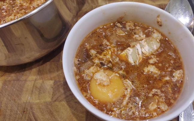 Un cuenco de sopa zurrukutuna complementada por una yema de huevo.