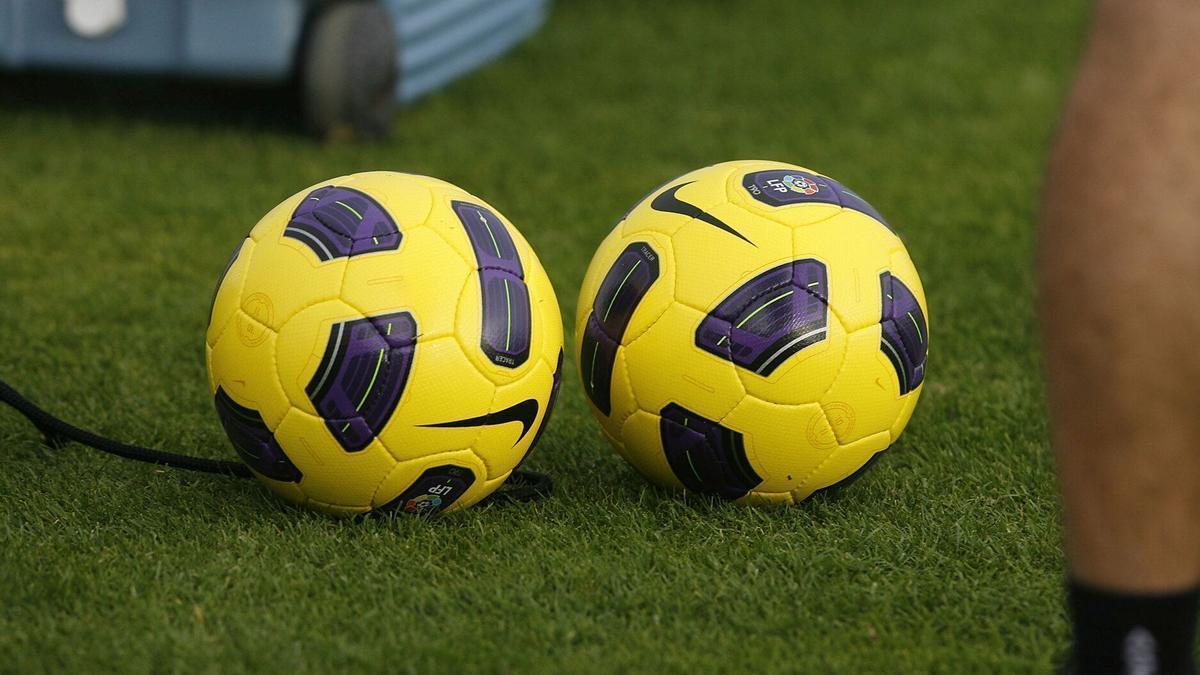 Dos balones en un campo de fútbol