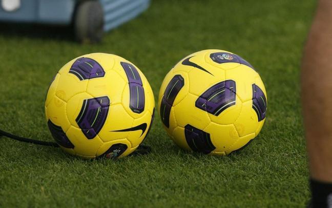 Dos balones en un campo de fútbol
