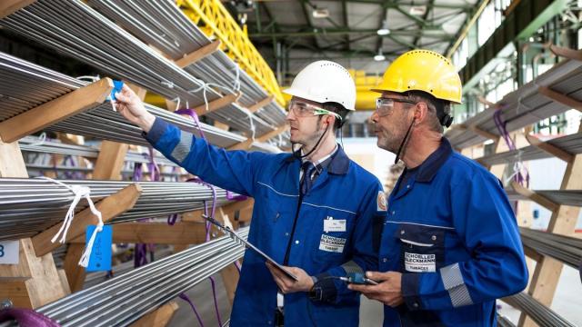 Dos empleados observan unos tubos tras su fabricación