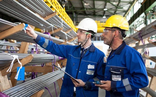 Dos empleados observan unos tubos tras su fabricación