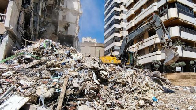 Una excavadora limpia los restros de un edificio bombardeado en Beirut.