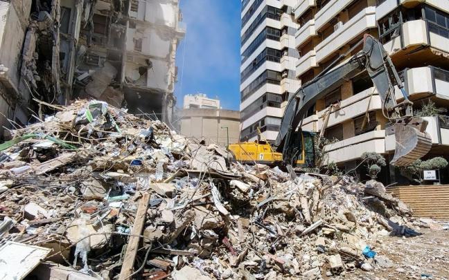 Una excavadora limpia los restros de un edificio bombardeado en Beirut.