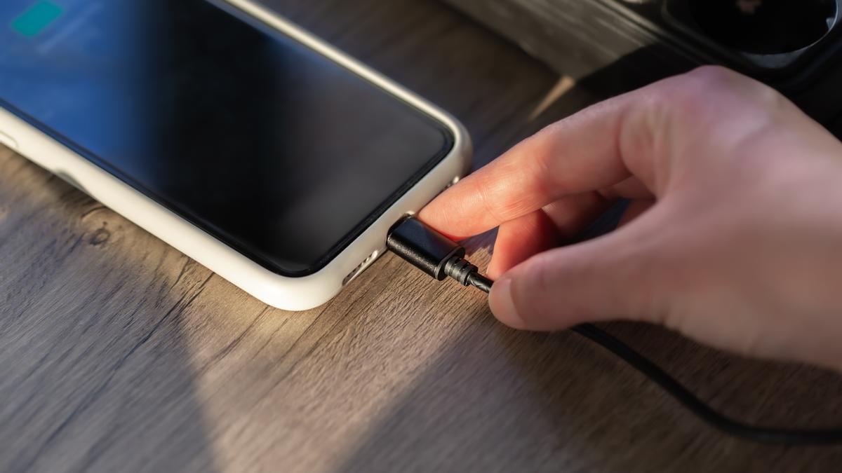 Persona carga su teléfono