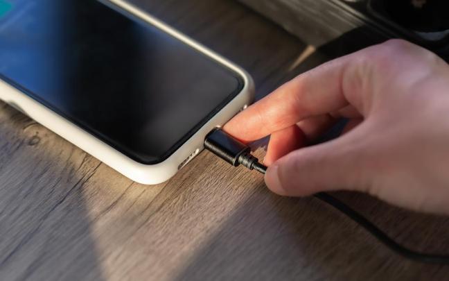 Persona carga su teléfono