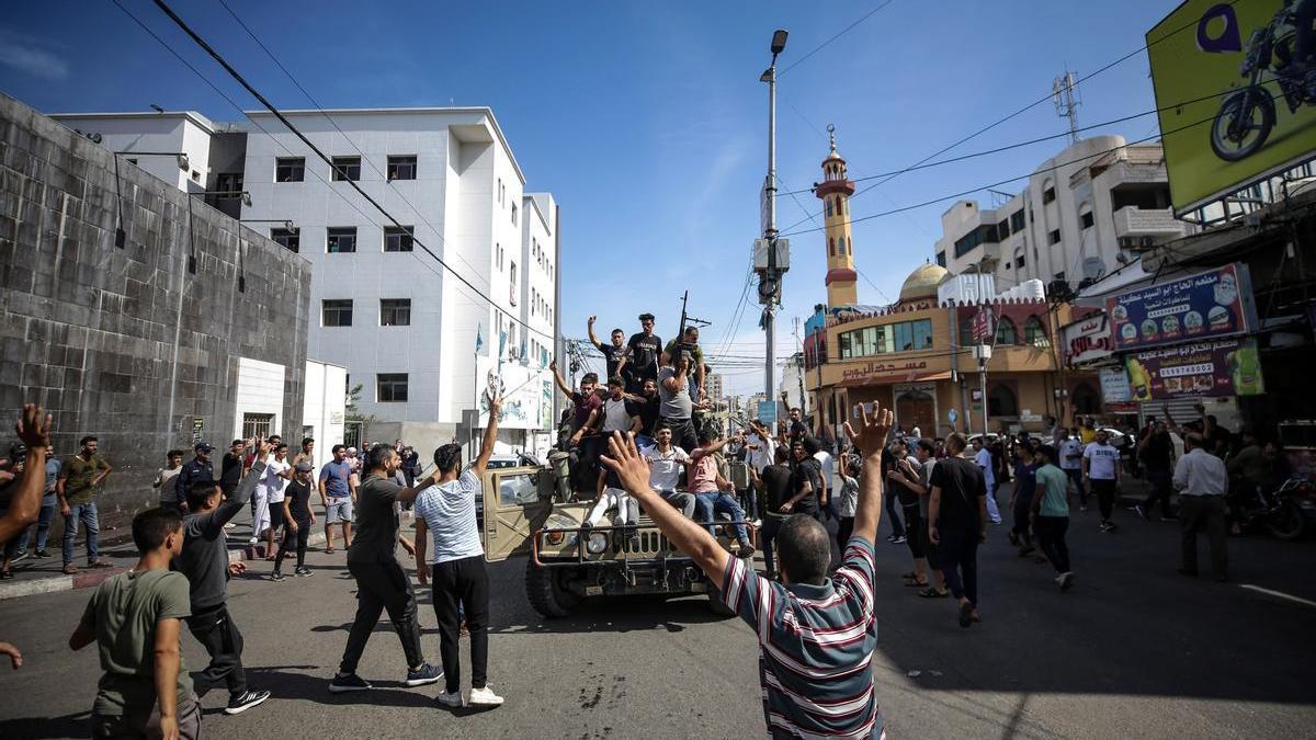 Los palestinos celebran el ataque de Hamás en un vehículo militar arrebatado a israel.