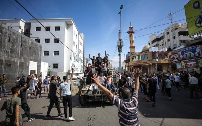 Los palestinos celebran el ataque de Hamás en un vehículo militar arrebatado a israel.