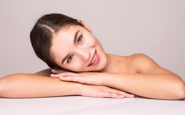 Una mujer joven luce una piel impecable en el rostro. Una mujer joven luce una piel impecable en el rostro.