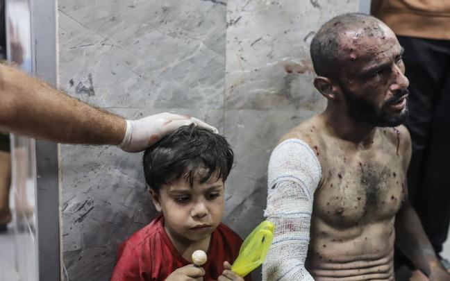 Un sanitario consuela a un niño en un hospital de Gaza tras un ataque israelí.