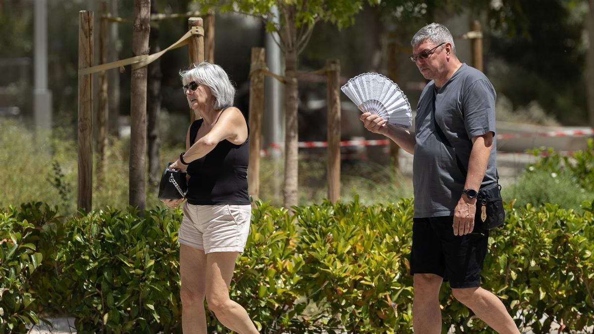 Dos personas paseando por Madrid en una jornada calurosa.