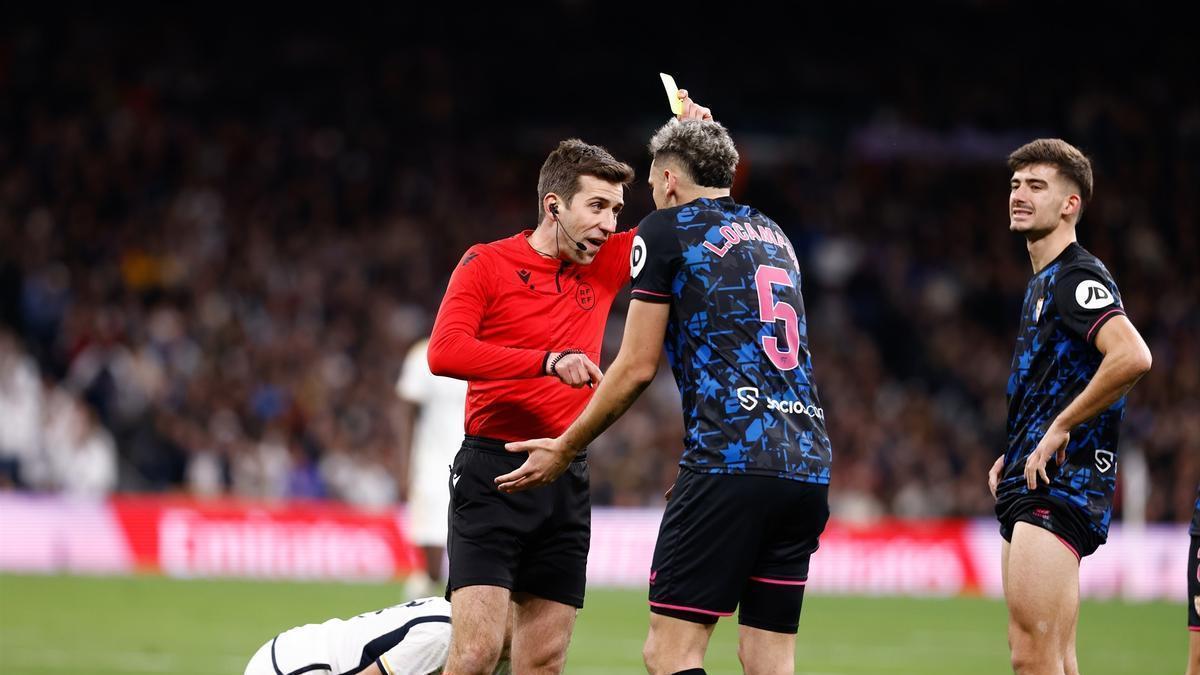 El árbitro muestra la amarilla al jugador del Sevilla Ocampos durante el partido de la semana pasada contra el Real Madrid.