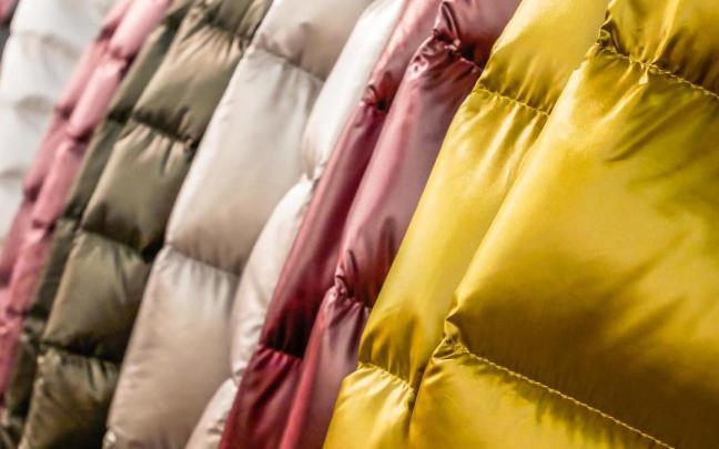 Plumíferos de distintos colores colgados en un perchero. Plumíferos de distintos colores colgados en un perchero.
