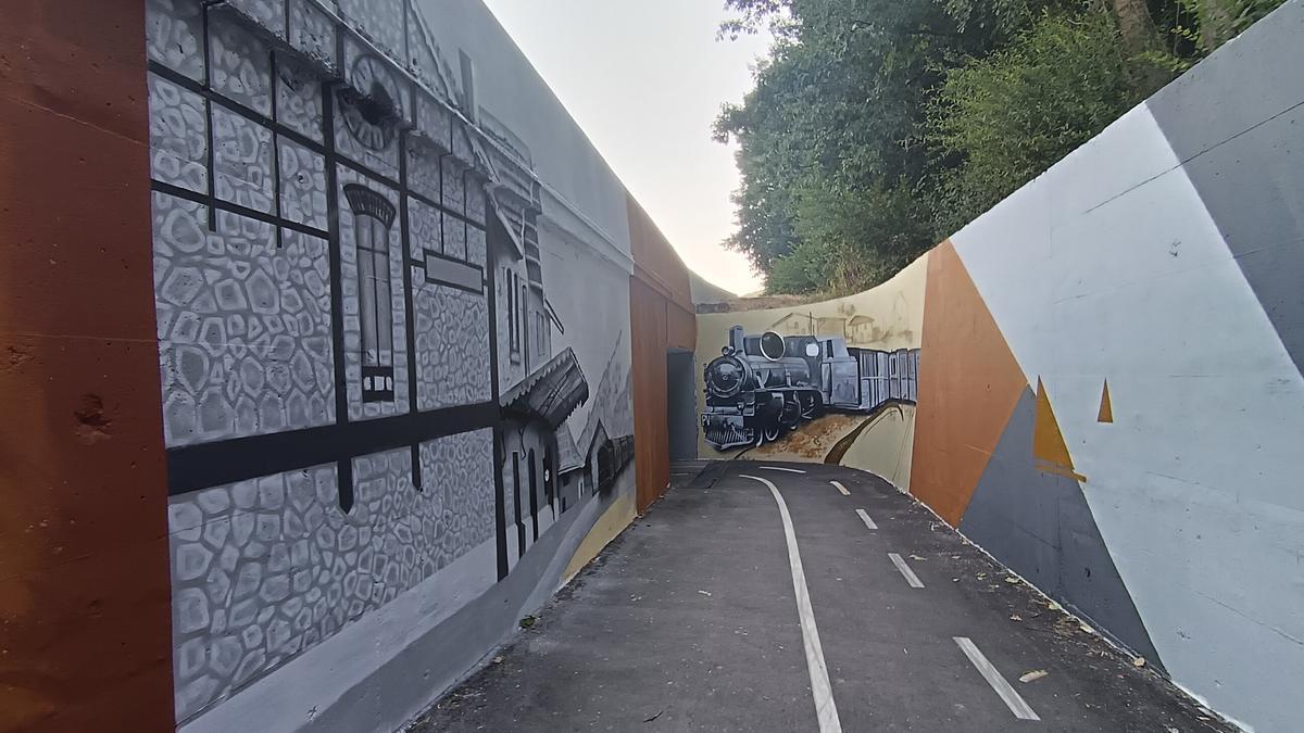 El acceso al túnel, llegando desde Eskoriatza, con la la antigua estación de Aretxabaleta y el tren.